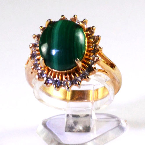 Ladies gold plated dress ring with a large oval shaped malachite centre stone surrounded by bright sparkling synthetic stones